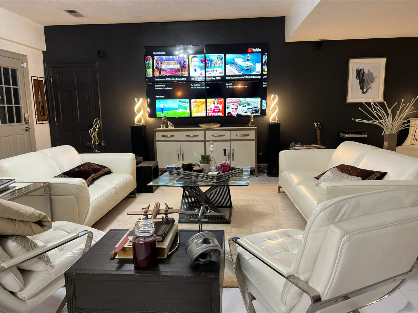 A living room with white couches and black walls
